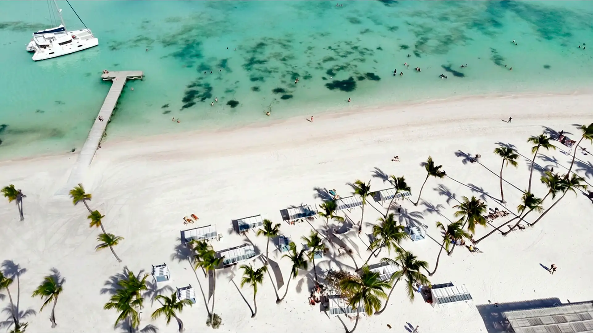 Aerial view of Juanillo Beach with white sand, palm trees and turquoise water, Cap Cana