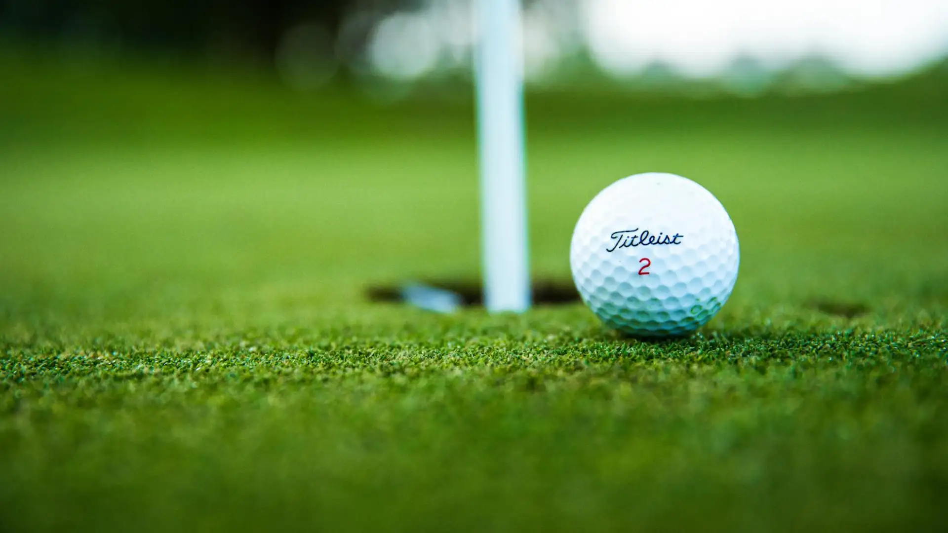 Golf ball next to the hole on the green at Las Iguanas Golf, Cap Cana
